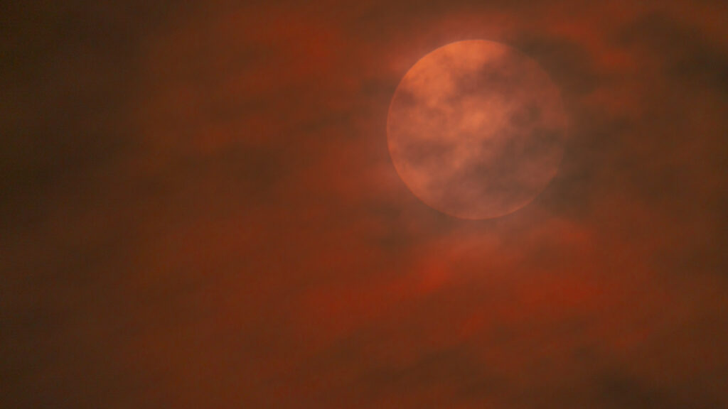 Foto van de maan achter de wolken